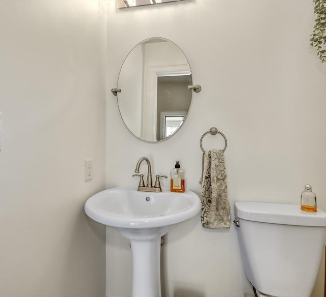 half bathroom with toilet and a sink