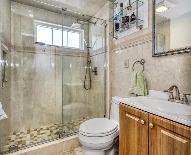 full bath with toilet, tile walls, a stall shower, and vanity