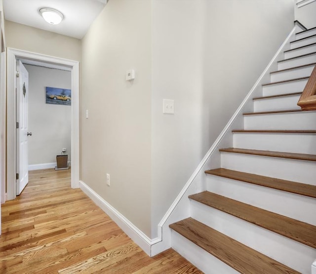 stairway featuring wood finished floors and baseboards