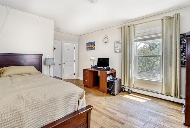 bedroom with a baseboard radiator and light wood-style floors