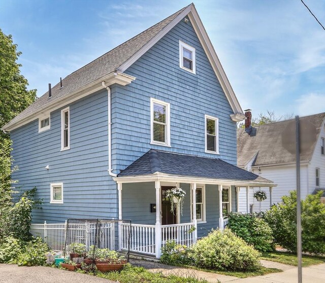 back of property featuring covered porch and fence