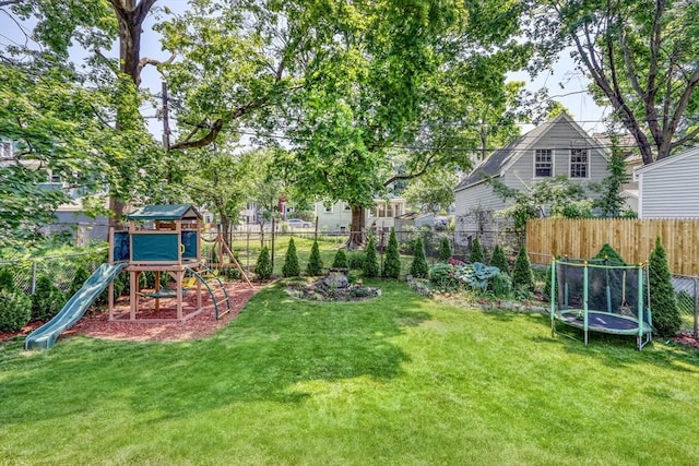 view of yard featuring a trampoline and a playground