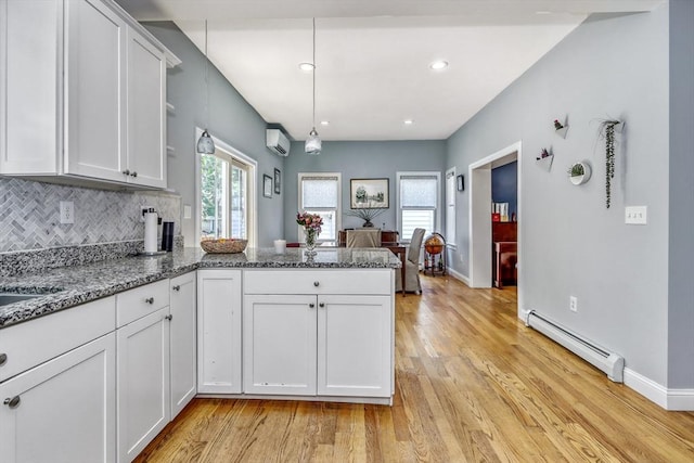 kitchen featuring a baseboard heating unit, a wall unit AC, a peninsula, open shelves, and white cabinetry