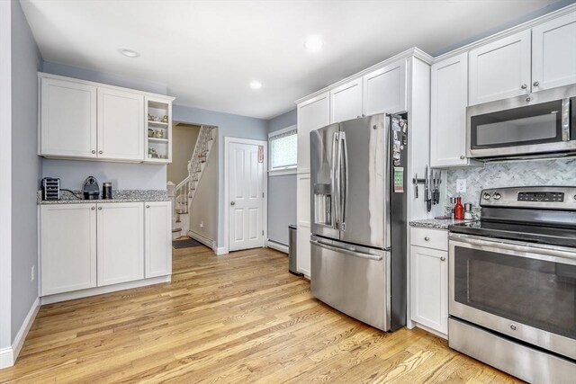 kitchen featuring stainless steel appliances, baseboard heating, light wood-type flooring, white cabinets, and recessed lighting