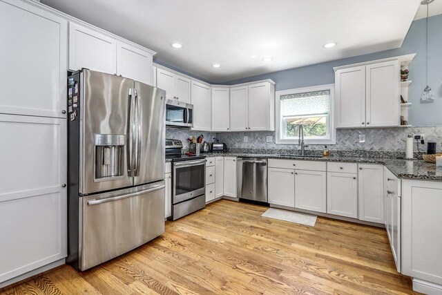 kitchen featuring stainless steel appliances, a sink, white cabinets, open shelves, and recessed lighting