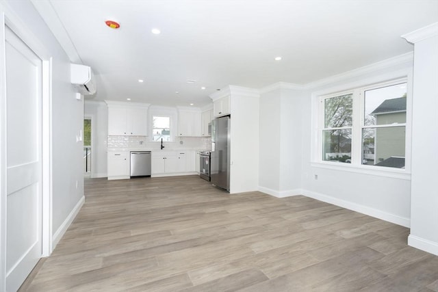 161 Sumner St Unit 1, Quincy, MA 02169 - unfurnished living room featuring baseboards, ornamental molding, an AC wall unit, light wood finished floors, and recessed lighting