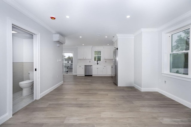 161 Sumner St Unit 1, Quincy, MA 02169 - unfurnished living room featuring an AC wall unit, a sink, recessed lighting, light wood-style floors, and crown molding