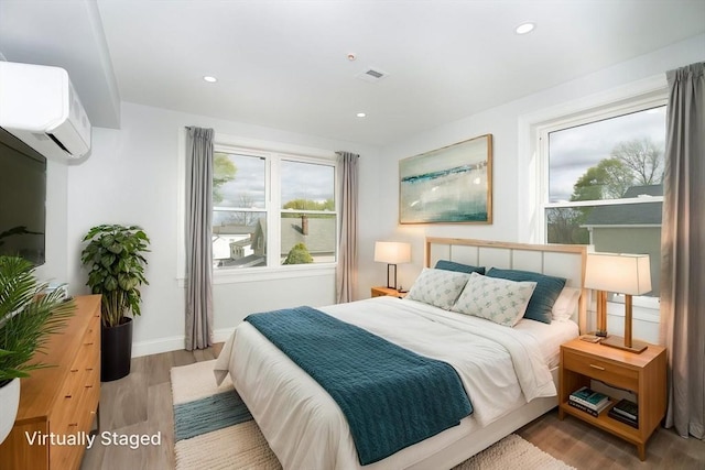 161 Sumner St Unit 1, Quincy, MA 02169 - bedroom featuring an AC wall unit, wood finished floors, recessed lighting, and baseboards