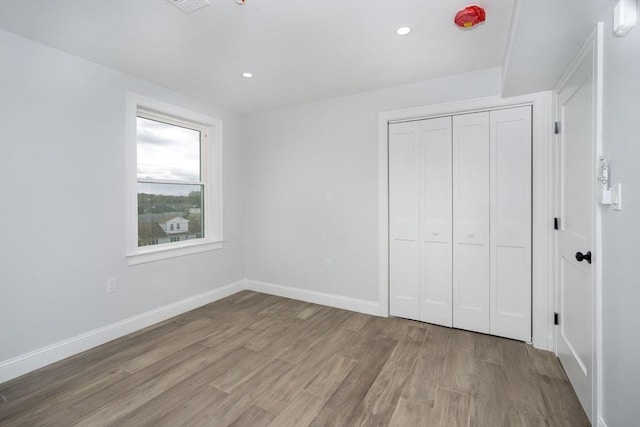 161 Sumner St Unit 1, Quincy, MA 02169 - unfurnished bedroom featuring wood finished floors, a closet, baseboards, and recessed lighting