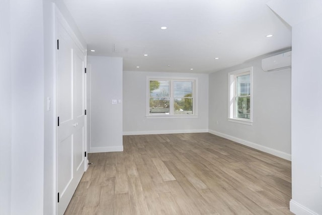 161 Sumner St Unit 1, Quincy, MA 02169 - unfurnished room featuring an AC wall unit, baseboards, light wood-type flooring, and recessed lighting