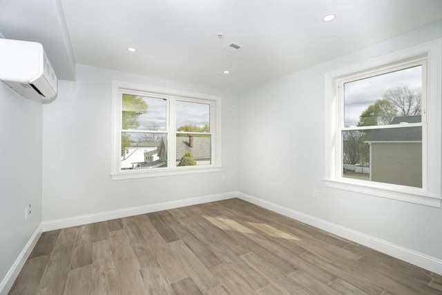 161 Sumner St Unit 1, Quincy, MA 02169 - unfurnished room featuring a wall unit AC, wood finished floors, baseboards, and recessed lighting
