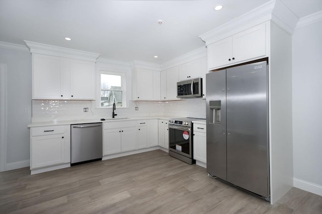 161 Sumner St Unit 1, Quincy, MA 02169 - kitchen with stainless steel appliances, a sink, decorative backsplash, white cabinets, and crown molding