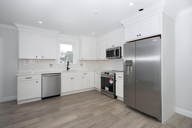 161 Sumner St Unit 1, Quincy, MA 02169 - kitchen with appliances with stainless steel finishes, a sink, ornamental molding, white cabinetry, and backsplash