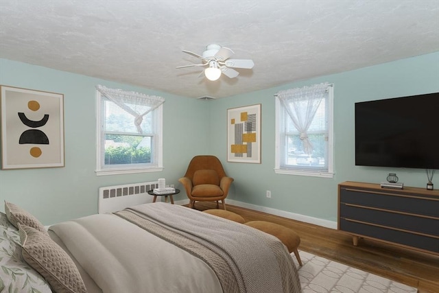 69 Gerald Rd, Milton, MA 02186 - bedroom featuring radiator, wood finished floors, a ceiling fan, and a textured ceiling