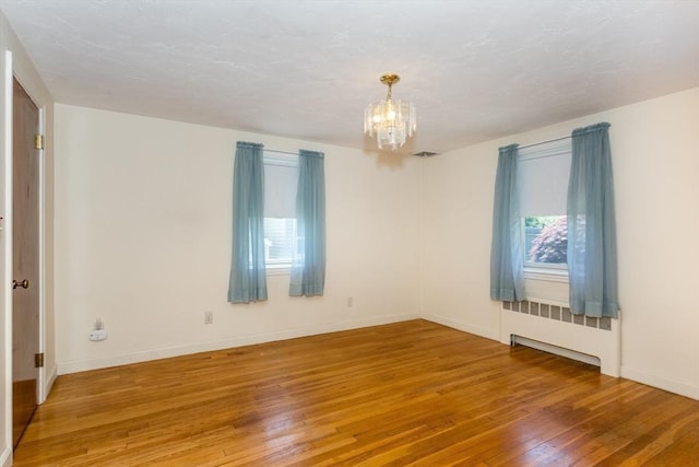 69 Gerald Rd, Milton, MA 02186 - empty room with wood-type flooring, a chandelier, and radiator heating unit