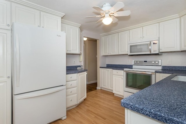 69 Gerald Rd, Milton, MA 02186 - kitchen with white appliances, light wood-style flooring, white cabinets, dark countertops, and ceiling fan