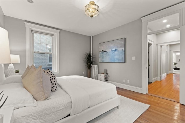 bedroom with radiator and light wood-type flooring