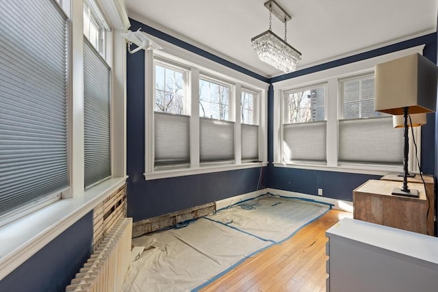 sunroom / solarium with a healthy amount of sunlight and a notable chandelier