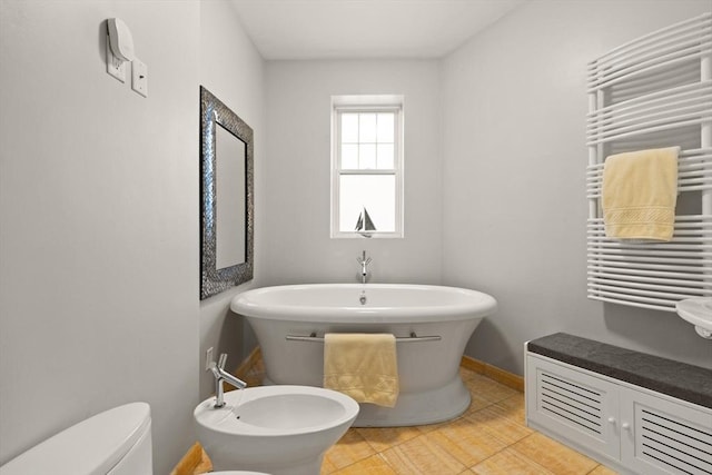 bathroom with tile patterned flooring, a bidet, radiator heating unit, and toilet