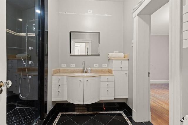 bathroom featuring a shower with door, vanity, and tile patterned floors