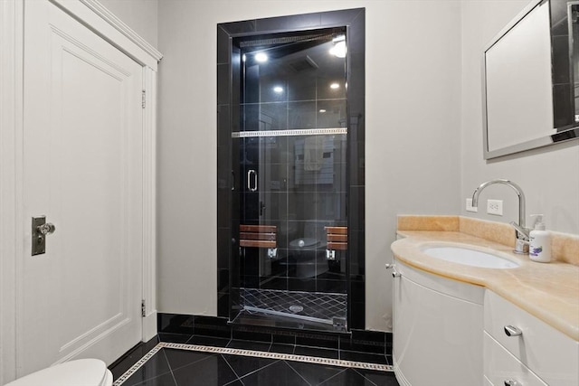 bathroom featuring tile patterned flooring, vanity, toilet, and a shower with shower door