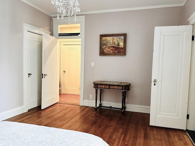 unfurnished bedroom featuring dark wood-type flooring, crown molding, and an inviting chandelier