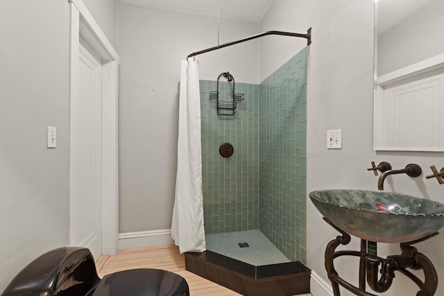 bathroom with hardwood / wood-style flooring, sink, and curtained shower