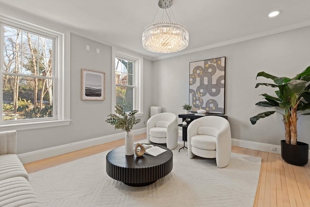 sitting room featuring an inviting chandelier, hardwood / wood-style floors, and crown molding