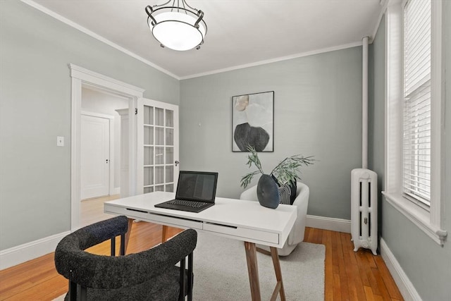 office with ornamental molding, radiator, and light wood-type flooring