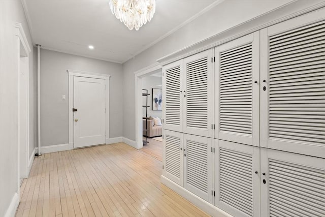 corridor featuring an inviting chandelier and light hardwood / wood-style floors