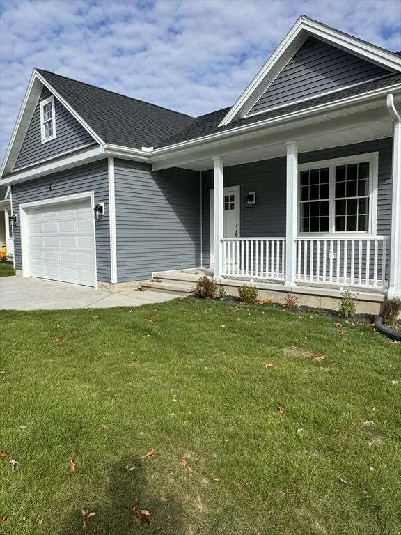 view of front facade featuring a garage, covered porch, and a front lawn