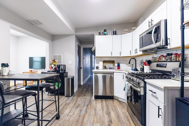 kitchen with backsplash, white cabinetry, sink, and appliances with stainless steel finishes