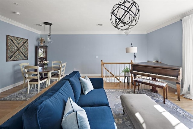 living area featuring baseboards, visible vents, ornamental molding, and wood finished floors