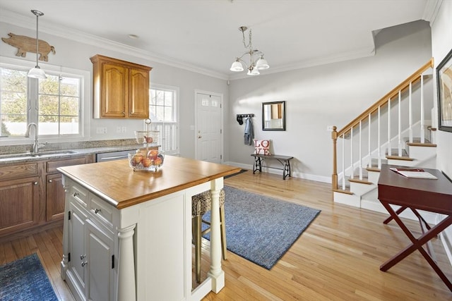 kitchen featuring a sink, a notable chandelier, light wood-type flooring, and a healthy amount of sunlight