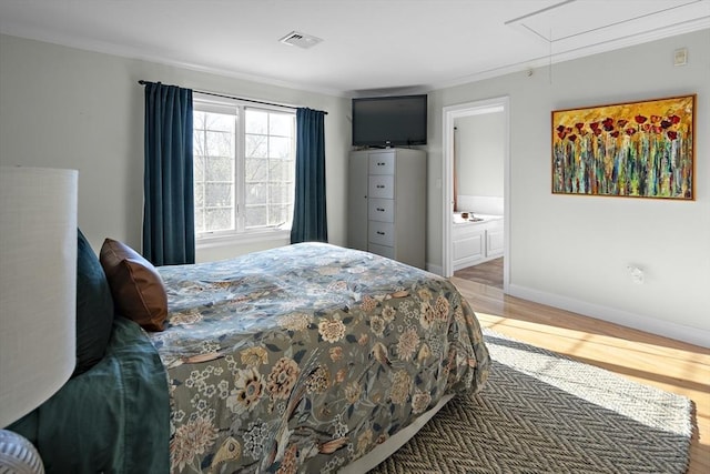 bedroom with visible vents, attic access, baseboards, and light wood-type flooring