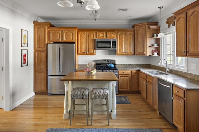 kitchen with visible vents, a sink, brown cabinetry, and appliances with stainless steel finishes