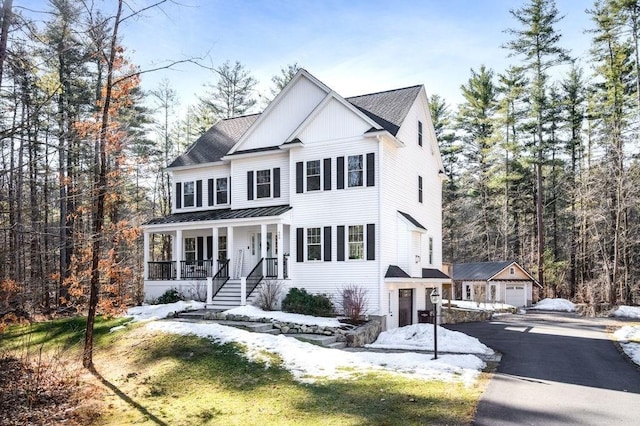 view of front of home featuring a standing seam roof, a porch, board and batten siding, an outdoor structure, and metal roof