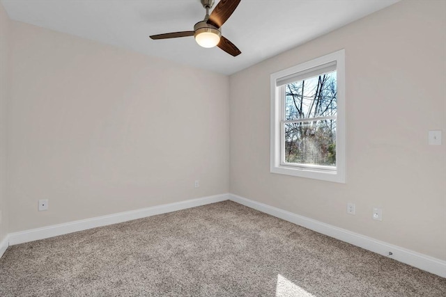 carpeted empty room with a ceiling fan and baseboards