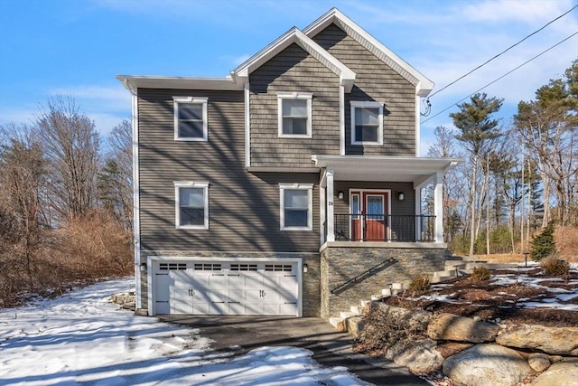 view of front facade featuring stairs, a porch, an attached garage, and aphalt driveway