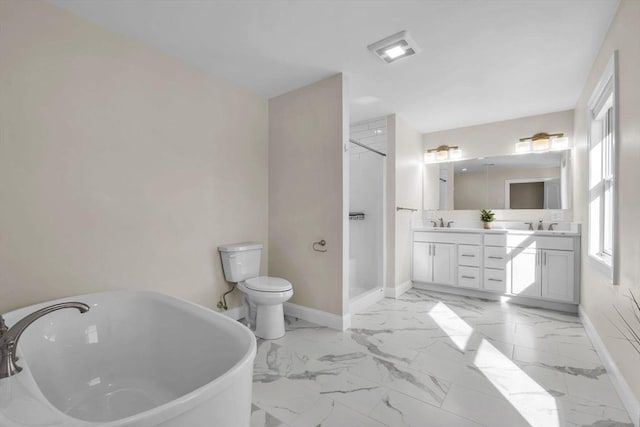 bathroom featuring marble finish floor, baseboards, a freestanding tub, and a sink