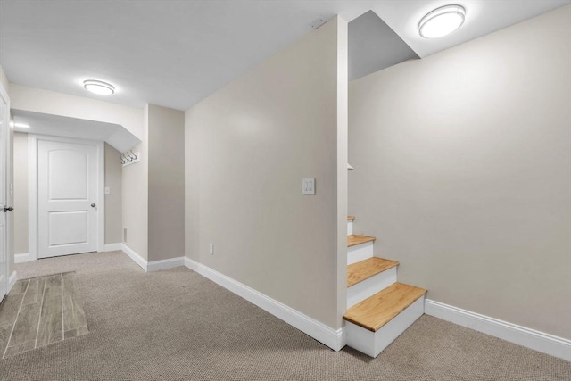 below grade area featuring stairs, carpet, and baseboards