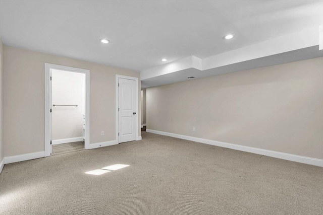 finished below grade area with recessed lighting, light colored carpet, and baseboards