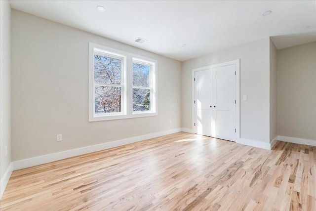 unfurnished bedroom featuring light wood-type flooring and a closet