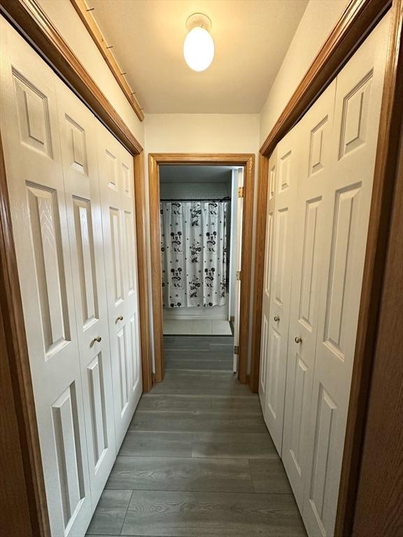 corridor featuring dark wood-style flooring