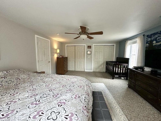carpeted bedroom with ceiling fan and multiple closets