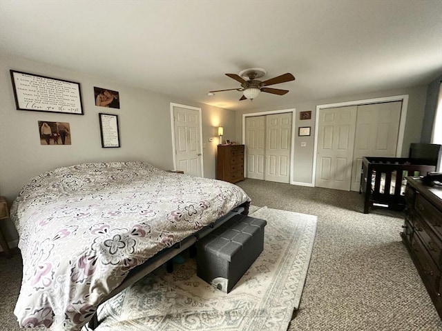 bedroom featuring carpet floors, a ceiling fan, and two closets