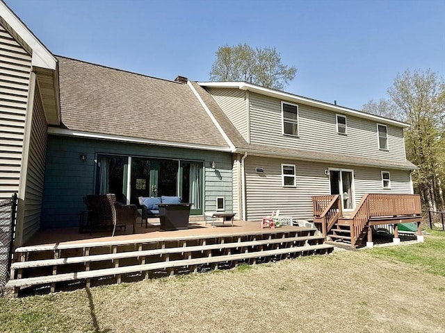 rear view of property featuring a shingled roof, outdoor lounge area, and a wooden deck