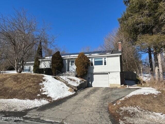 view of front of house with a garage and solar panels