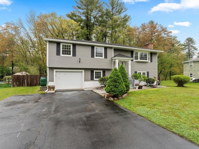 split foyer home with a chimney, driveway, and an attached garage
