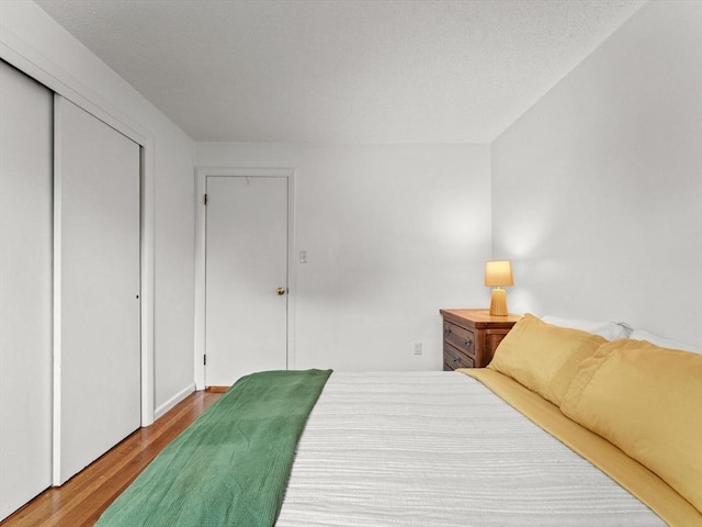 bedroom with wood finished floors and a closet